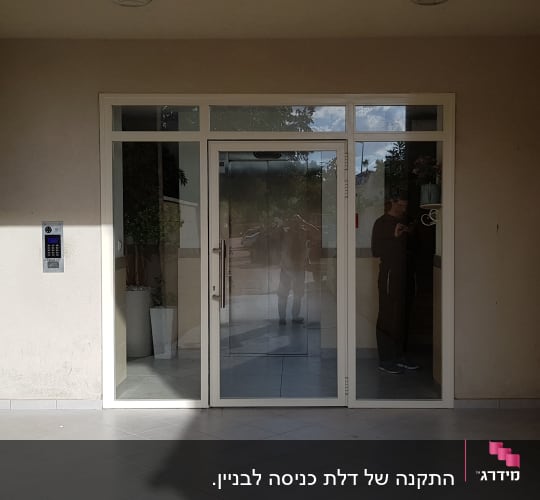 דלת זכוכית עם מסגרת אלומיניום בכניסה לבניין
